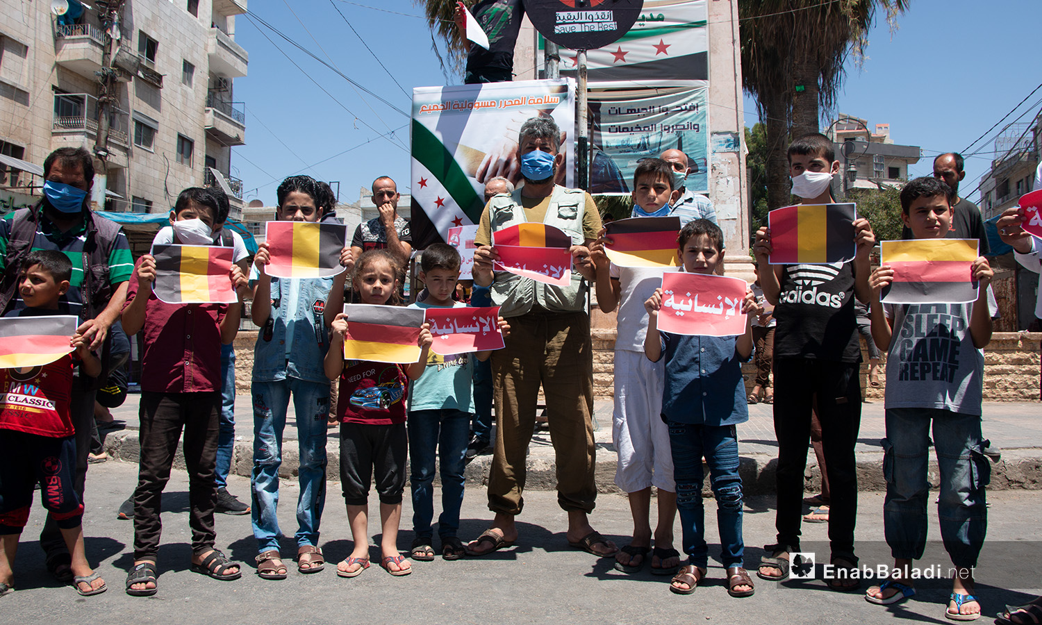 Children and young men carrying signs during a protest stand in Idlib city – 17 July 2020 (Enab Baladi / Anas al-Khouli)