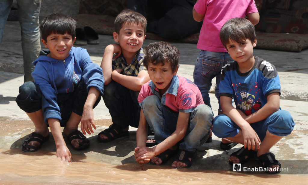 Children playing with leaked water due to the breakdowns of the water pipes system that provides water for the al-Bab city in northern Aleppo countryside – 20 June 2020 (Enab Baladi / Asim Melhem)
