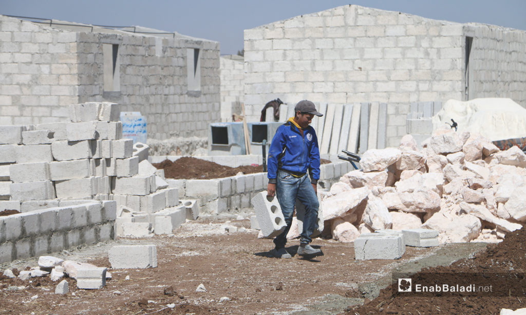 A construction worker of the concrete housing units' project to replace the makeshift tents. This project is conducted by humanitarian organizations and bodies operating in northern Syria in Bahorta village of northern Aleppo countryside – 26 June 2020 (Enab Baladi / Abdul Salam Majan)