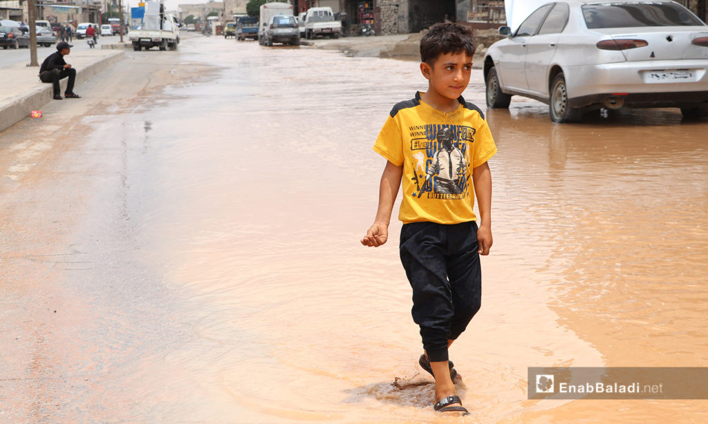 A child walking through leaked water due to the breakdowns of the water pipes system that provides water for the al-Bab city in northern Aleppo countryside – 20 June 2020 (Enab Baladi / Asim Melhem)