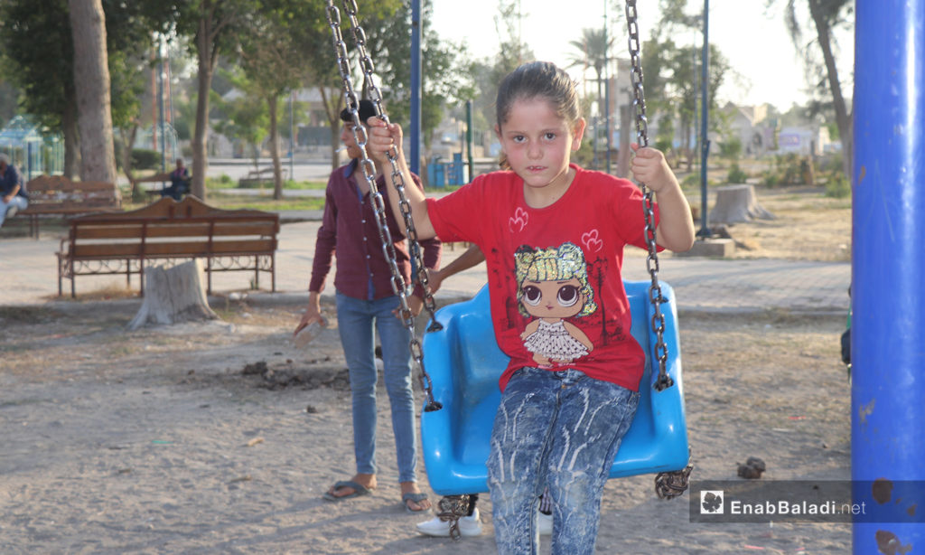 A child riding the swing in one of the parks in al-Raqqa city - 26 July 2020 (Enab Baladi / Abdul Aziz Saleh)
