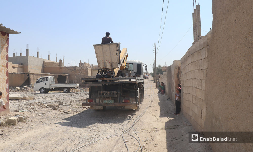 The installation of electric cables and equipping of utility poles in al-Rmaila and al-Huni neighborhoods in al-Raqqa city – 11 August 2020 (Enab Baladi / Abdul Aziz al-Saleh)