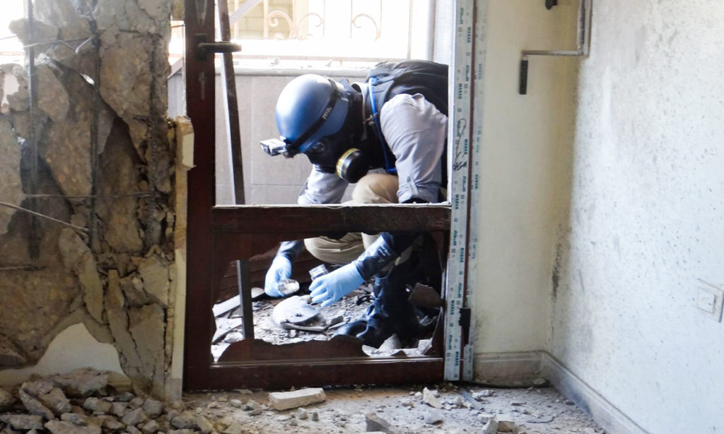 A UN expert collecting samples to investigate the chemical weapons attack in Eastern Ghouta - 2013 (AFP)