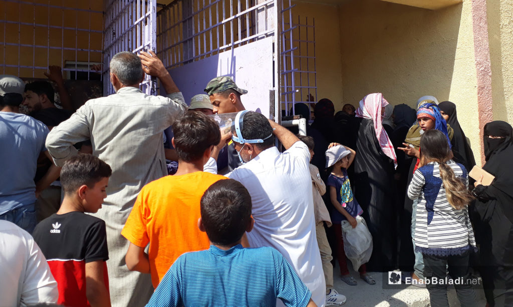Syrian citizens overcrowded at a bakery in al-Raqqa city – 06 August 2020 (Enab Baladi / Abdul Aziz al-Saleh)
