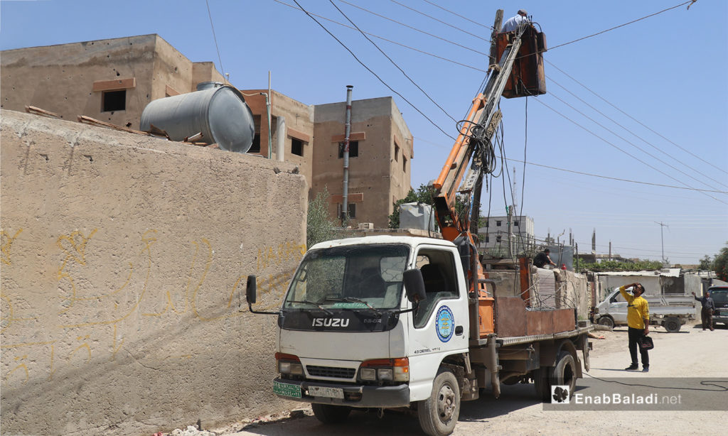 The installation of electric cables and equipping of utility poles in al-Rmaila and al-Huni neighborhoods in al-Raqqa city – 11 August 2020 (Enab Baladi / Abdul Aziz al-Saleh)