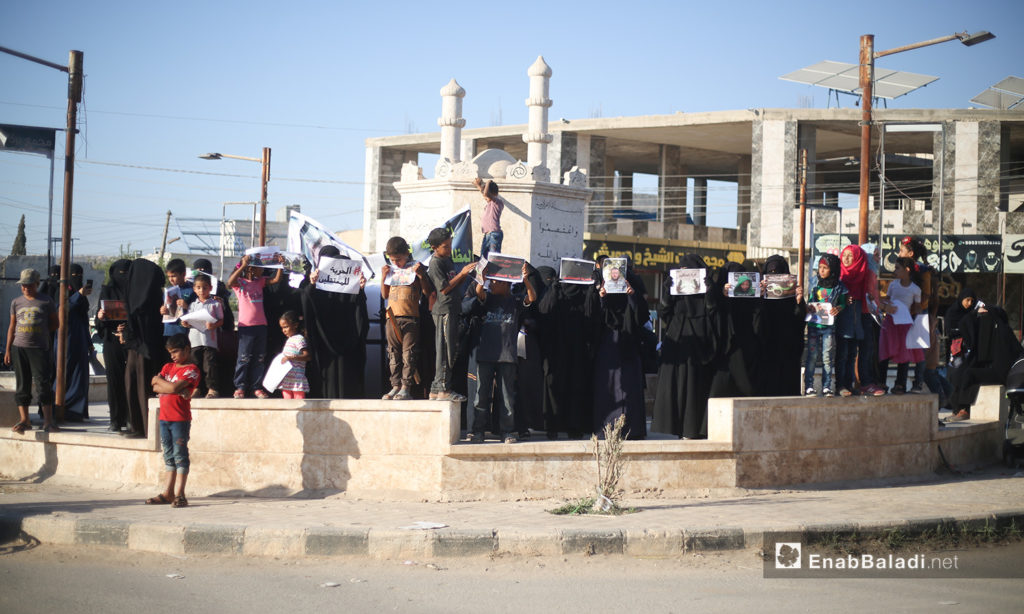 A protest stand demanding the release of the British aid worker Tauqir Sharif, known as “Abu Hussam the British” and the American journalist Darrell Lamont Phelps, nicknamed “Bilal Abdul Kareem” in Atmeh of Idlib countryside – 20 August 2020 (Enab Baladi / Yousef Ghuraibi)