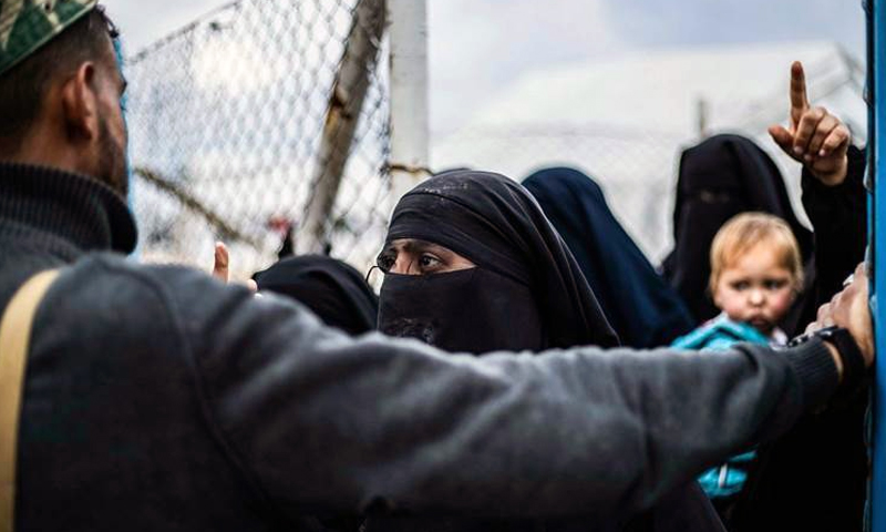 A female resident of al-Hawl camp, east of Hasakah, faces a camp guard - 2019 (AFP)