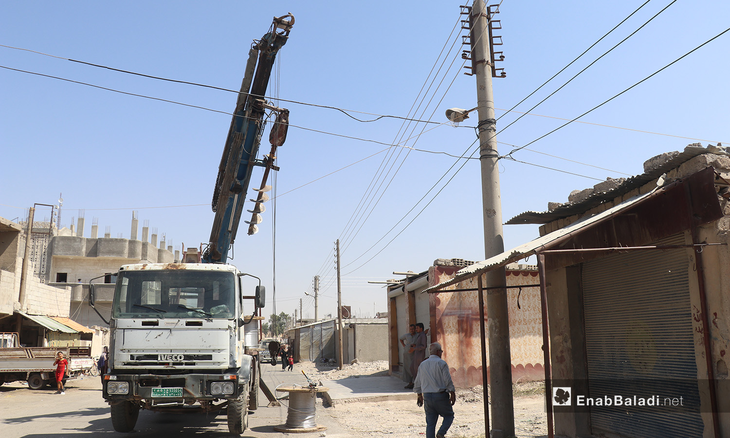 The installation of electric cables and equipping of utility poles in al-Rmaila and al-Huni neighborhoods in al-Raqqa city – 11 August 2020 (Enab Baladi / Abdul Aziz al-Saleh)
