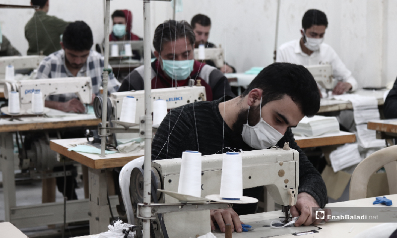 Workers in a factory for manufacturing protective face masks in the city of Idlib - 29 March 2020 (Enab Baladi/Youssef Gharib)