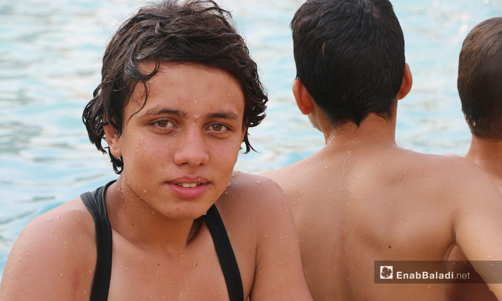 A group of boys in the water at Idlib’s municipal swimming pool - September 2020 (Enab Baladi / Anas al-Khouli)