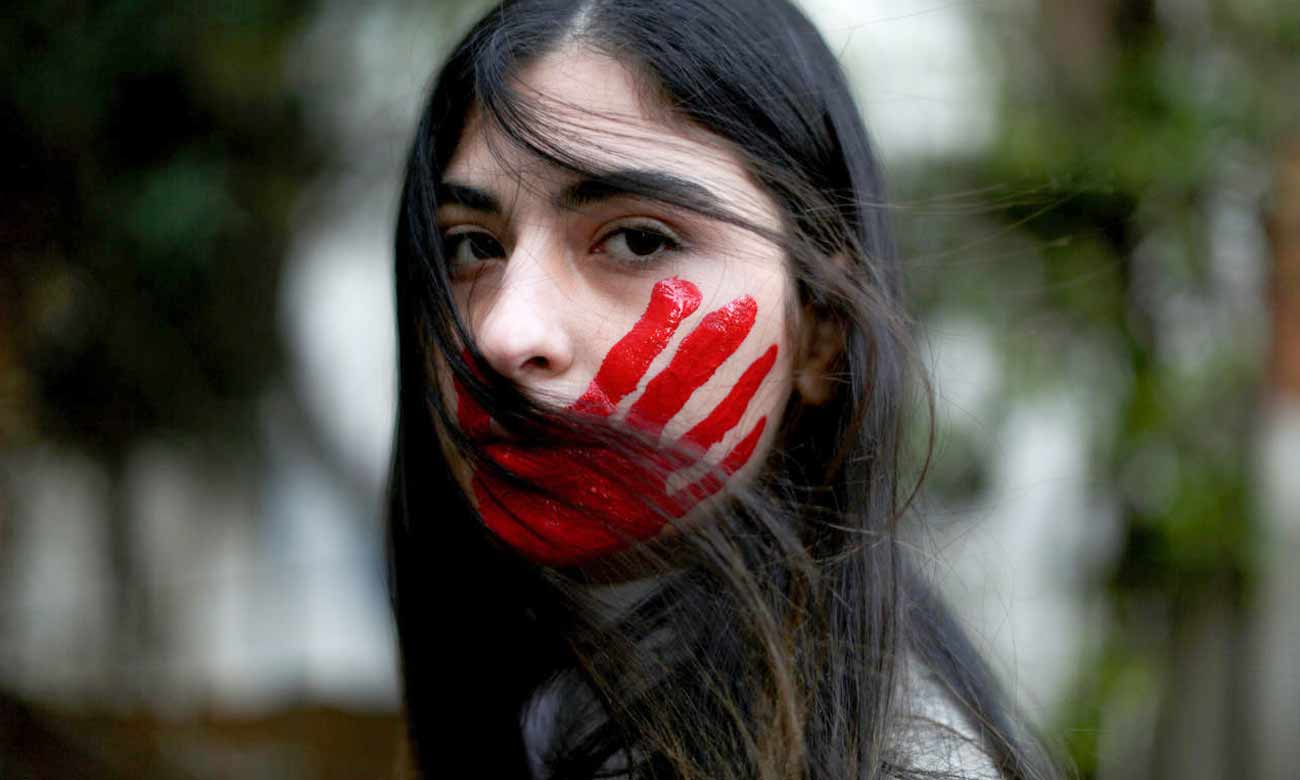 A Lebanese woman poses with her face painted with a red hand during a demonstration against sexual harassment in the Lebanese capital, Beirut - 7 September 2019 (AFP)