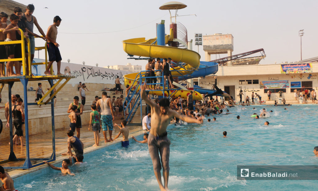 People swimming at Idlib’s municipal swimming pool to escape the summer’s heat – September 2020 (Enab Baladi / Anas al-Khouli)