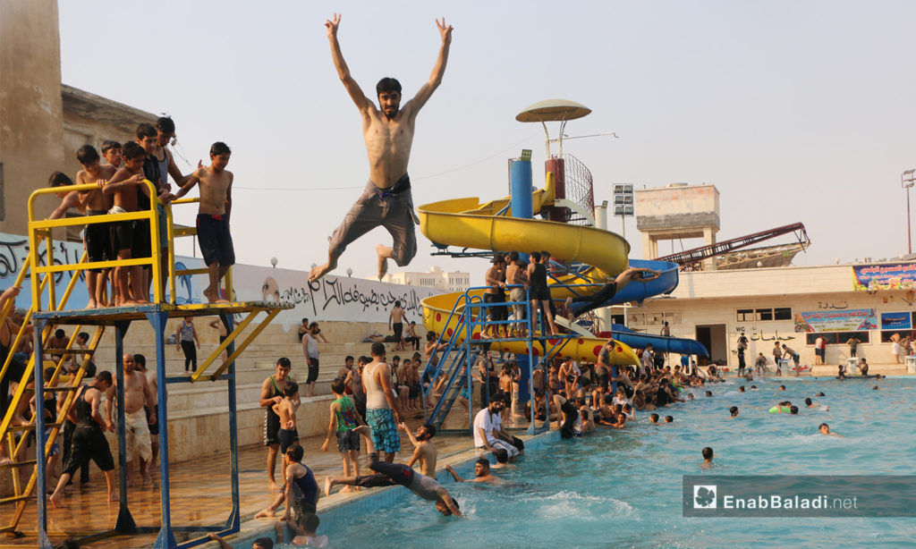 A man jumping into the water in Idlib’s municipal swimming pool – September 2020 (Enab Baladi / Anas al-Khouli)