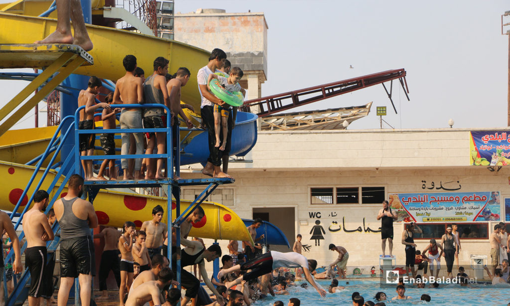 Crowds of children and young men who want to jump in Idlib’s municipal swimming pool - September 2020 (Enab Baladi / Anas al-Khouli)