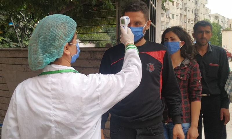 Wearing masks, people lined up for temperature checks before entering the Bassel Hospital as a part of the coronavirus preventive measures. 