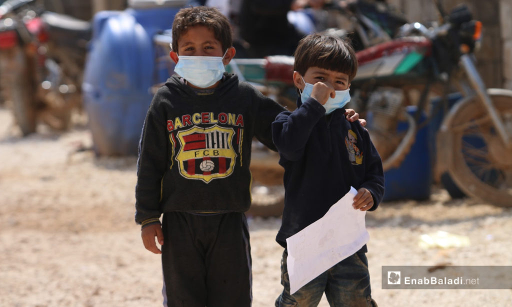 Two children wearing protective facial masks against the coronavirus in the camps of Atmah in the northern Idlib countryside - 17 March 2020 (Enab Baladi / Yousef Ghuraibi)
