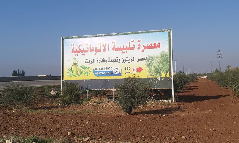 A billboard sign of the automatic olive oil mill in Talbiseh city on the Hama-Homs highway - 10 December 2020 (Enab Baladi - Orwah al-Mundhir)