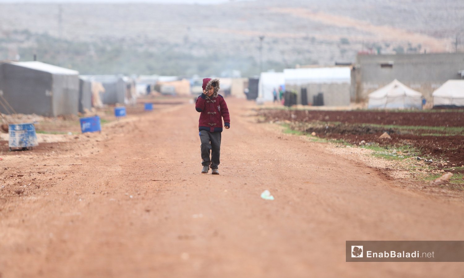 A child walking against the wind in al-Dana displacement camps - 15 December 2020 (Enab Baladi-Youssef Gharibi)