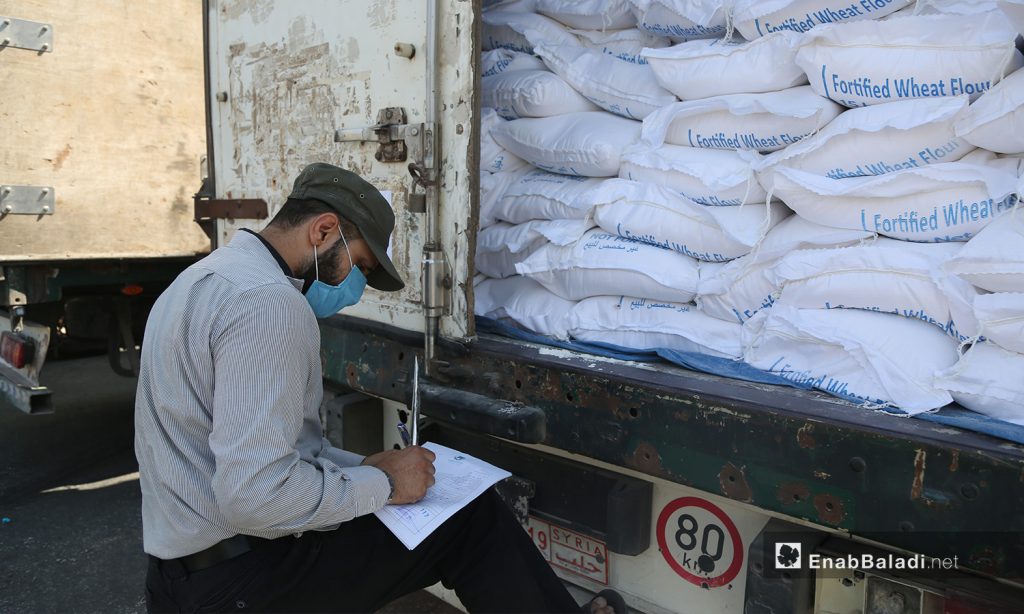 Employee at Bab al-Hawa Border Crossing between Syria and Turkey counting aid items delivered to Syria —18 September 2020 (Enab Baladi / Youssef Ghuraibi)