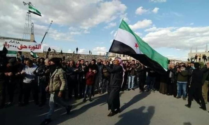 A protester in Daraa raising the flag of the Syrian revolution - 18 March 2021 (Facebook)