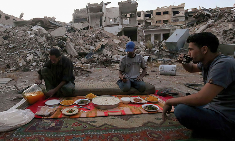 Syrian family break Ramadan fast amidst the rubble of buildings bombed by the Syrian regime in Ghouta (Anadolu)