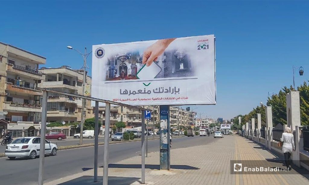 A billboard calling people to take part in the Syrian presidential elections - 12 May 2021 (Enab Baladi - Orwah al-Mundhir)
