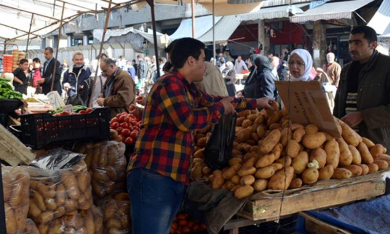 A greengrocer selling potatoes in Souq al-Hal Market  in Damascus (Athr Press)