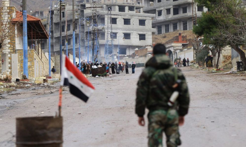 A Syrian regime soldier standing at a checkpoint at the entrance of Madaya town in Damascus countryside- 14 January 2016 (AFP)