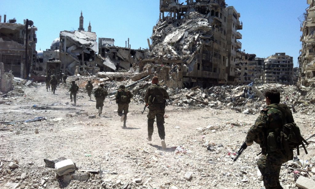 Members of the Syrian regime forces participating in the battles of the al-Khalidiya neighborhood in Homs city - July 2013 (AFP)