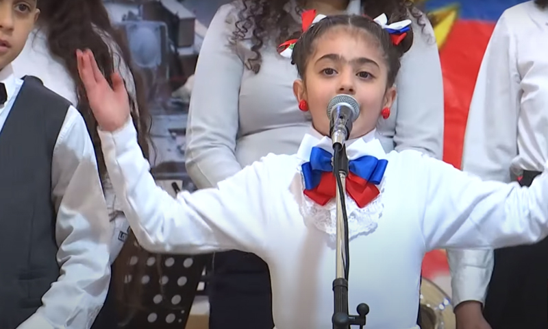 A Syrian child chanting a Russian song at Hmeimim airbase (RT)