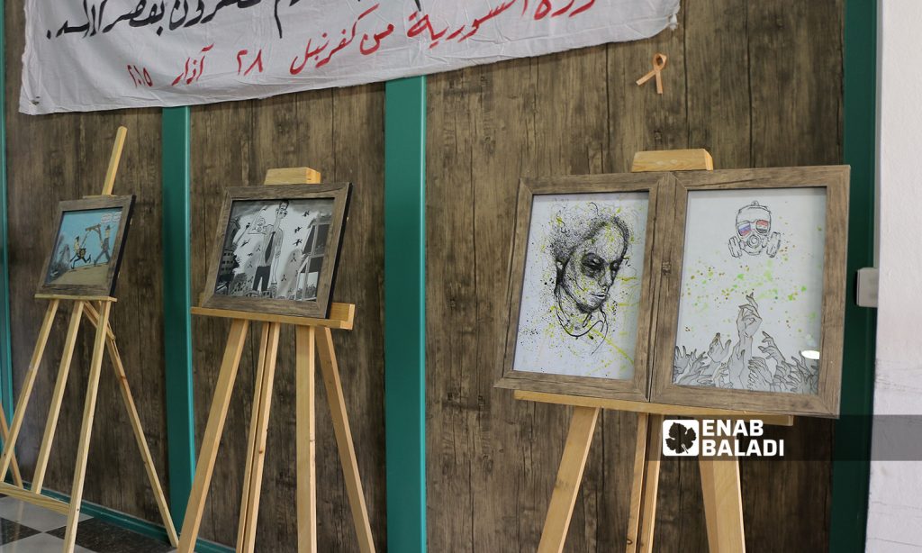 Paintings displayed at an art exhibition held in remembrance of the Eastern Ghouta’s chemical massacre - 21 August 2021 (Enab Baladi / Walid Othman)