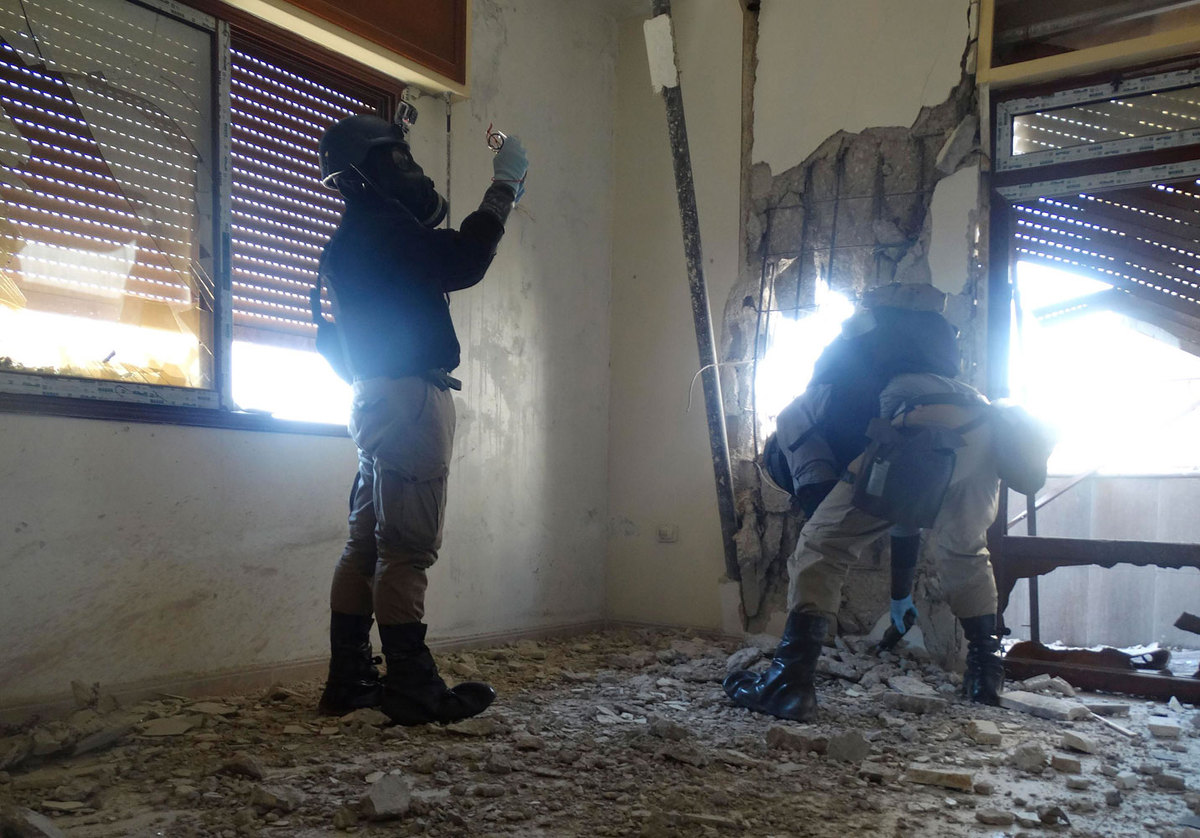 UN chemical weapon experts, wearing gas masks while inspecting one of the sites of a chemical attack in the town of Zamalka in Eastern Ghouta – 29 August 2013 (Reuters)