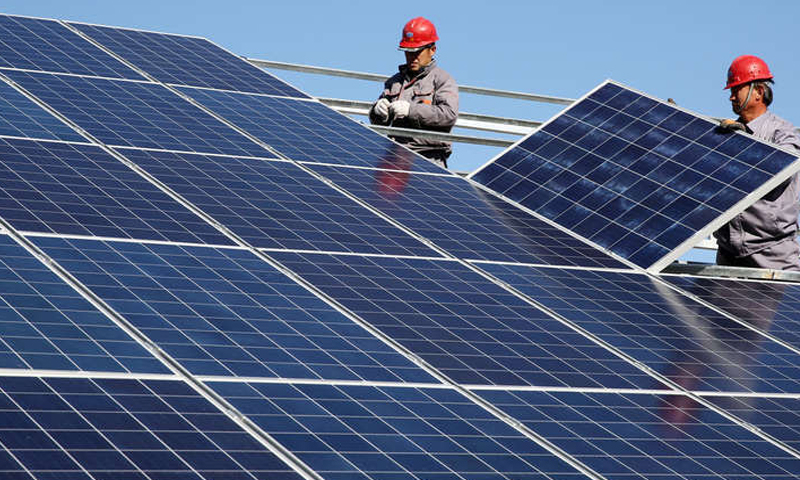 Two technicians installing solar power panels in one of the Syrian cities (Reuters)