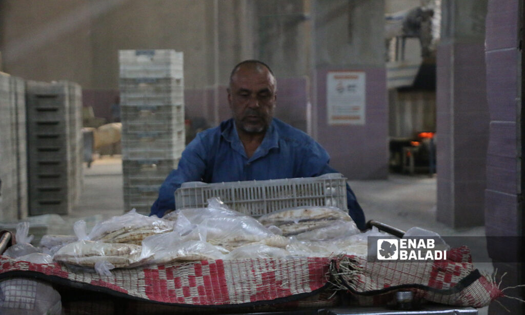 A worker putting bread pundles in a truck in the al-Bab city’s automated bakery - 8 October 2021 (Enab Baladi - Siraj Mohammed)
