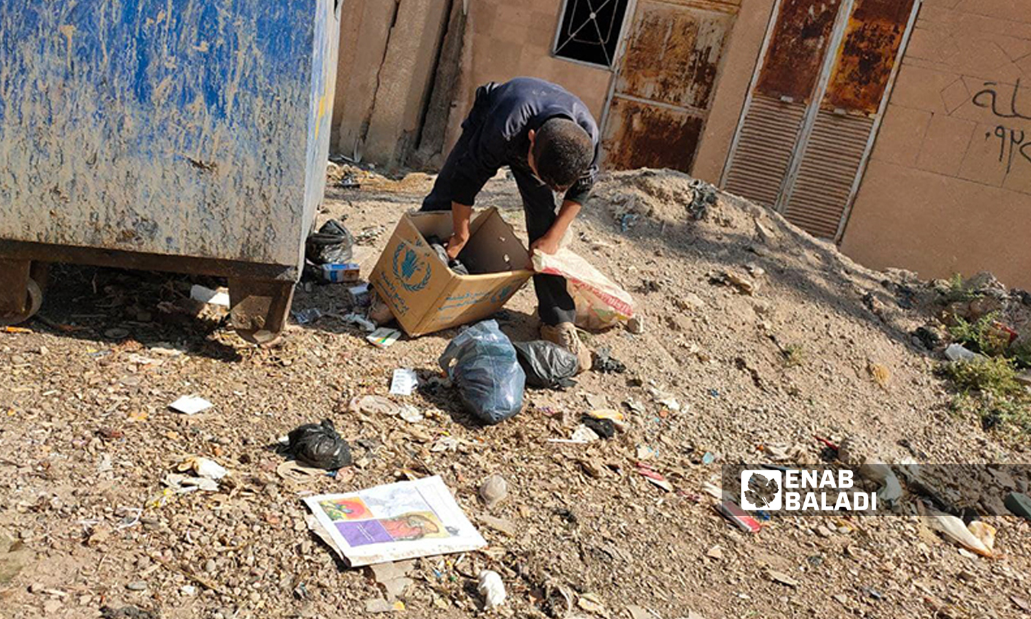 A Syrian child looking for empty plastic bottles near a dumpster in Qamishli city - 9 October 2021 (Majd al-Salem/Enab Baladi)