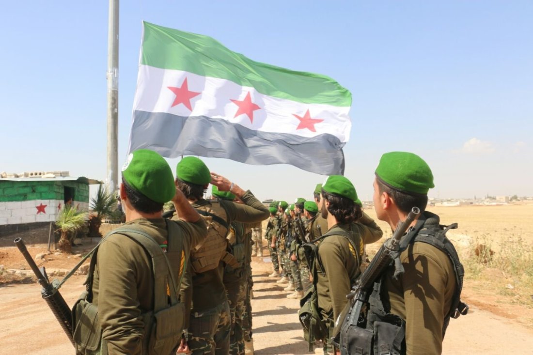 A group of the Syrian National Army (SNA)’s elements paying tribute to the flag of the Syrian Revolution - 2020 (Anadolu Agency)