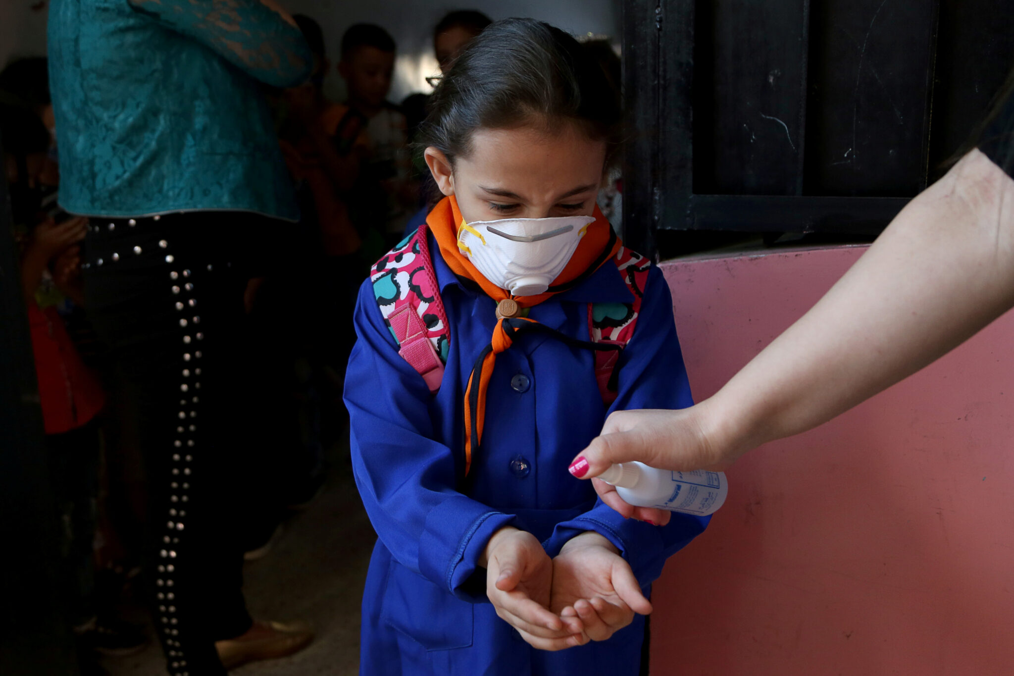 A Syrian student sanitizing her hands for protection against the coronavirus (COVID-19) pandemic (Reuters)