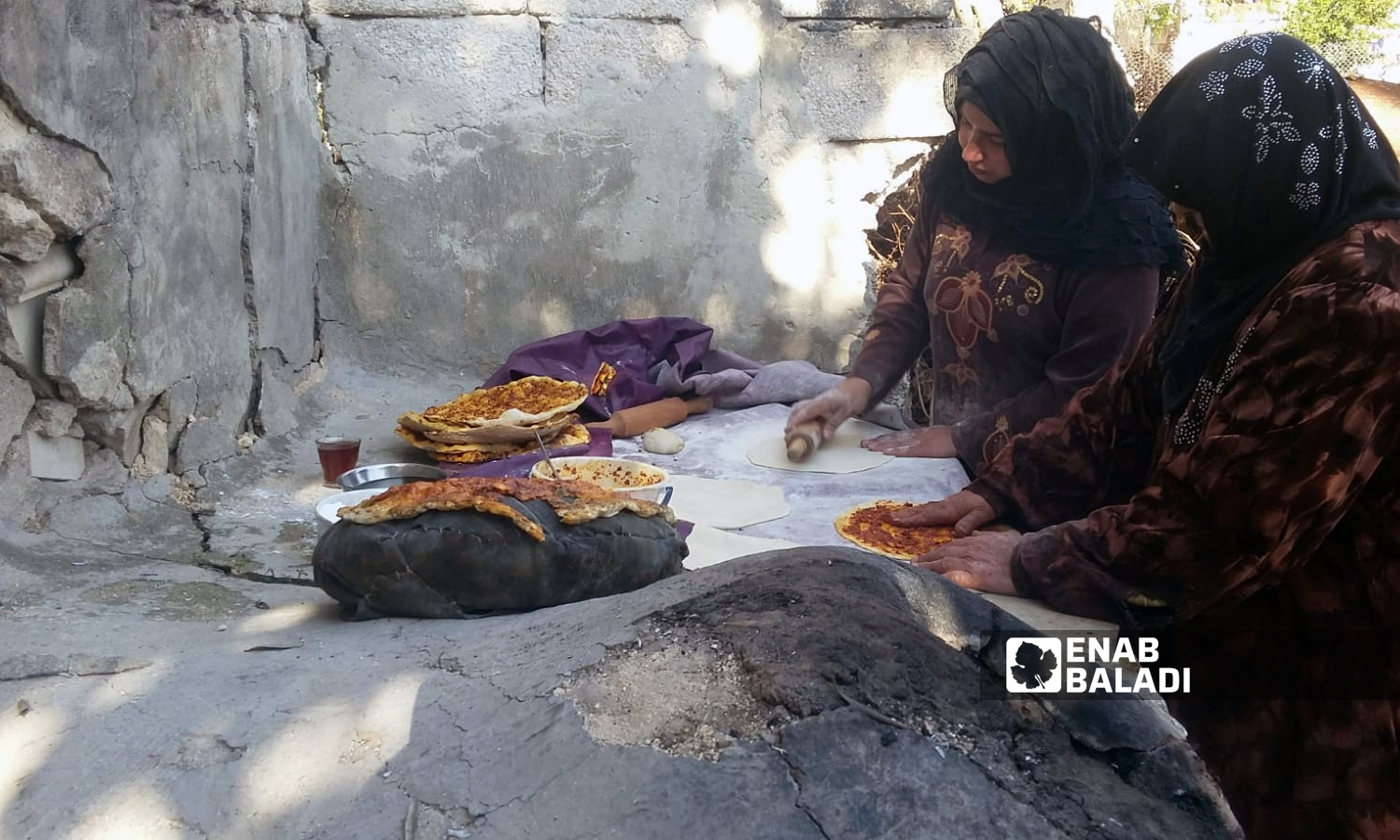 Syrian women baking tandoor bread in Idlib, northwestern Syria - 29 November 2021 (Enab Baladi/Hadia al-Mansour)