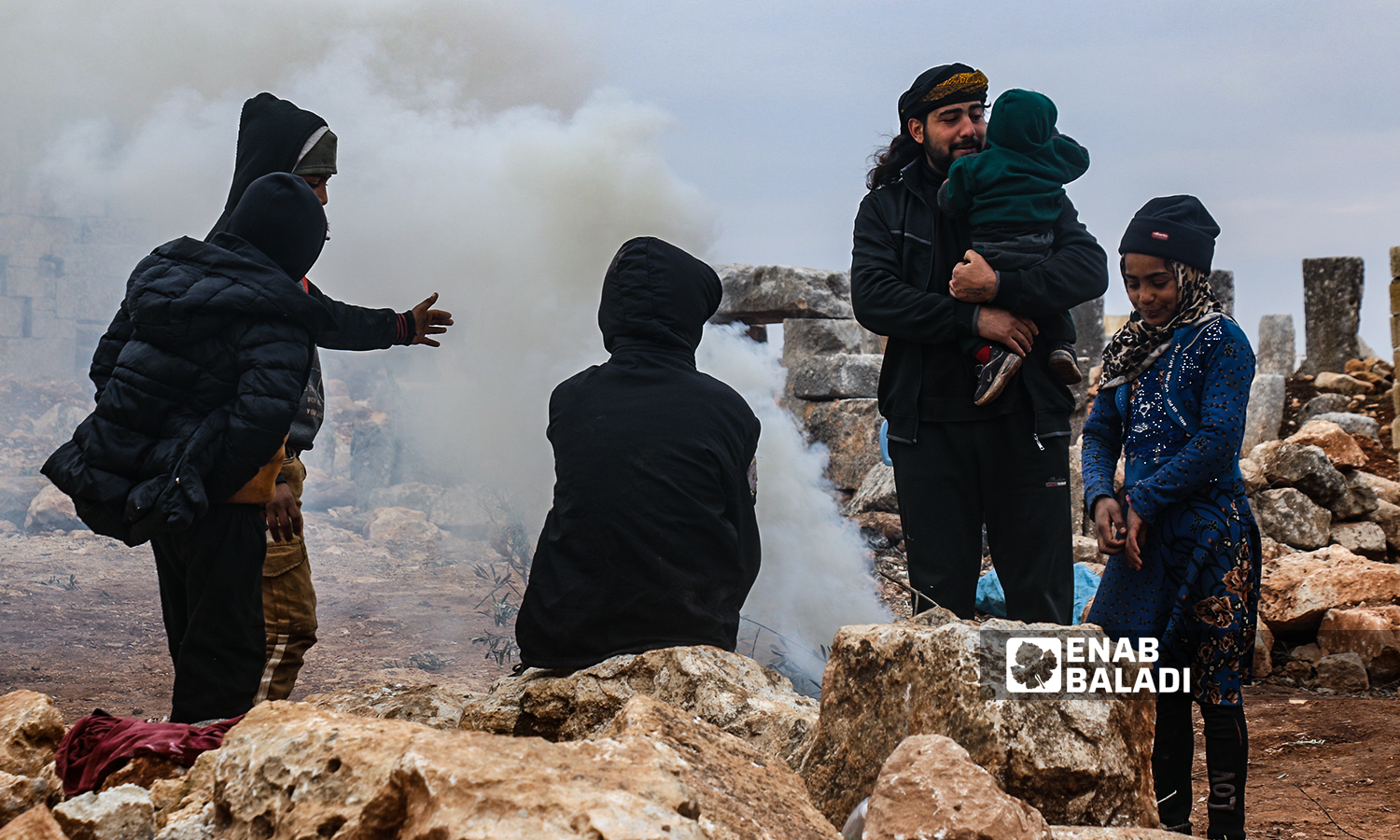 Displaced Syrians starting a fire for heating in the ancient Sarjableh area in the northern countryside of Idlib governorate - 22 January 2022 (Enab Baladi / Iyad Abdul Jawad)
