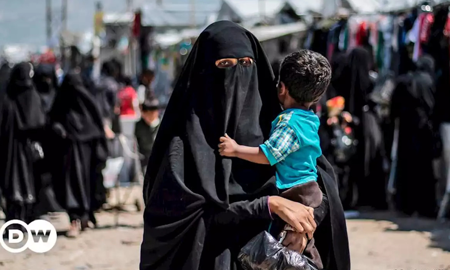 A woman carrying her child in al-Hol camp in northeastern Syria - 2019 (AFP)