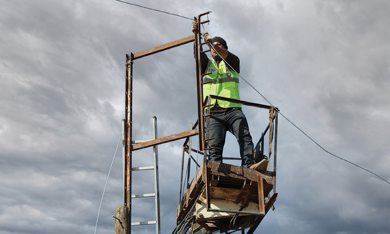 A worker at the Syrian-Turkish Electricity Company (STE) rehabilitating a power line in Afrin city