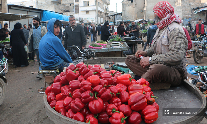 A greengrocer sitting on his cart in the main market of Idlib city - 7 April (Enab Baladi)