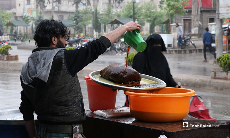 A Licorice seller in the city of al-Bab in northern Aleppo governorate during the rainy Ramadan weather - 24 April (Enab Baladi)