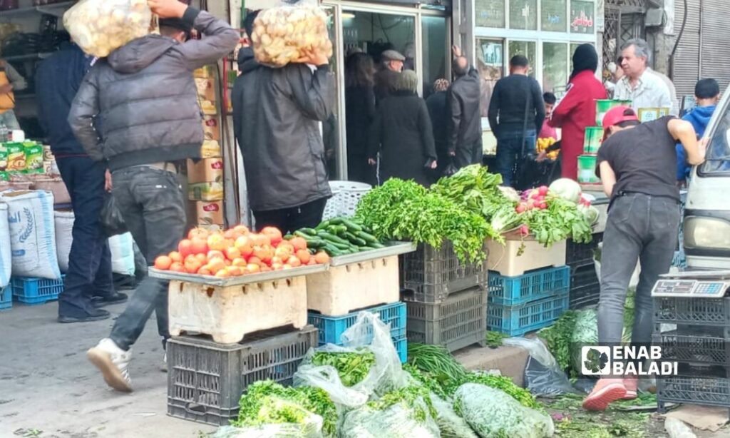 A greengrocer at the Ugarit street market located between al-Owaineh and Slaybeh neighborhoods in coastal Latakia city - 2 April 2022 (Enab Baladi)