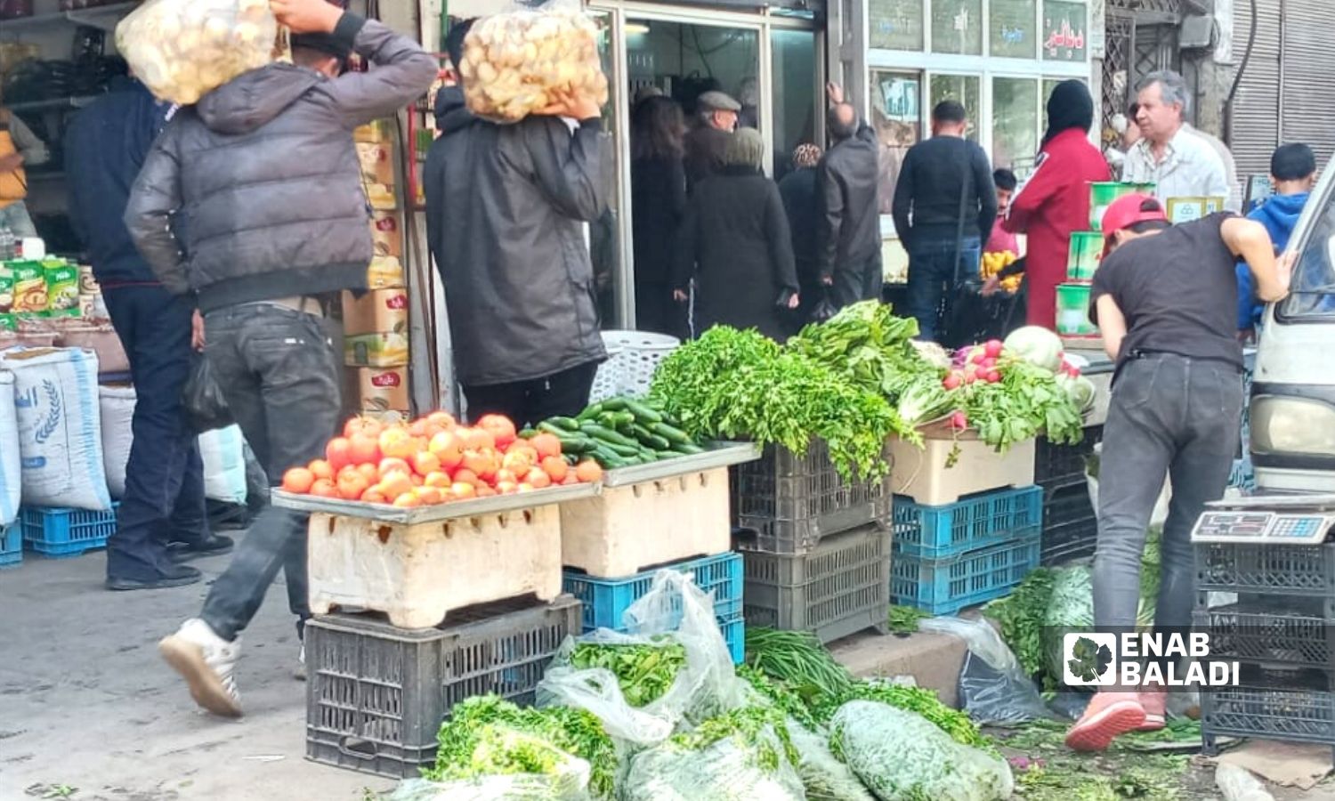 A vegetable seller in Ugarit street market located between al-Owaineh and Slaybeh neighborhoods in Latakia city - 2 April 2022 (Enab Baladi)
