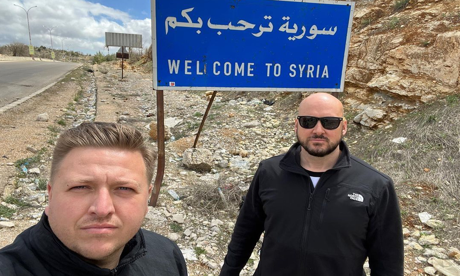 A still from a video clip of British YouTuber Simon Wilson in front of a road banner on the Syrian-Lebanese border - 12 April 2022 (Simon Williams’ Facebook page)