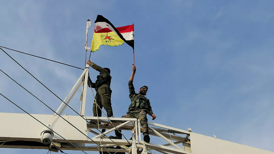 A regime army soldier and SDF fighter raise the flags of both sides in Ayn al-Arab city in the countryside of Aleppo - 20 October 2019 (Sputnik)