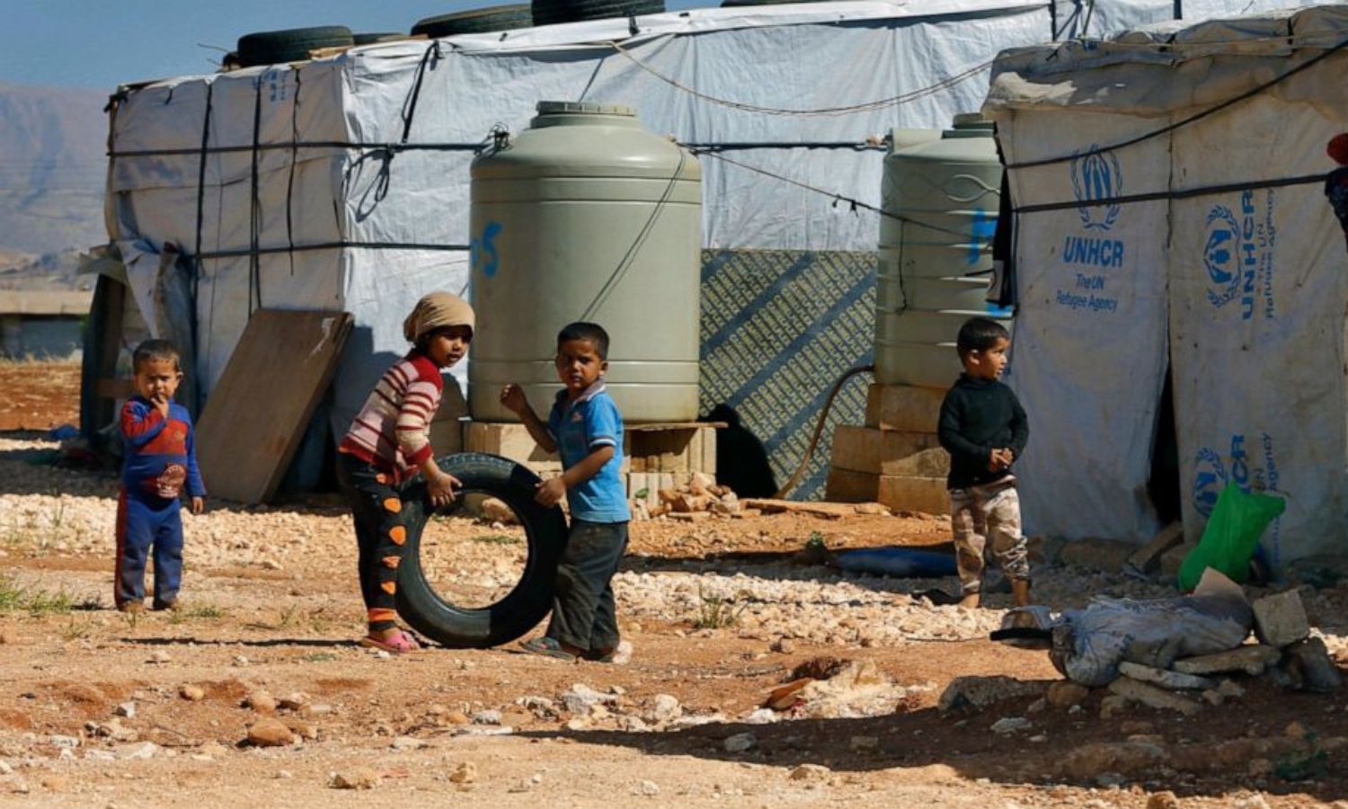Syrian refugee children playing outside their families’ tents in a refugee camp in Baalbek city, Lebanon - 20 June 2017 (AP)
