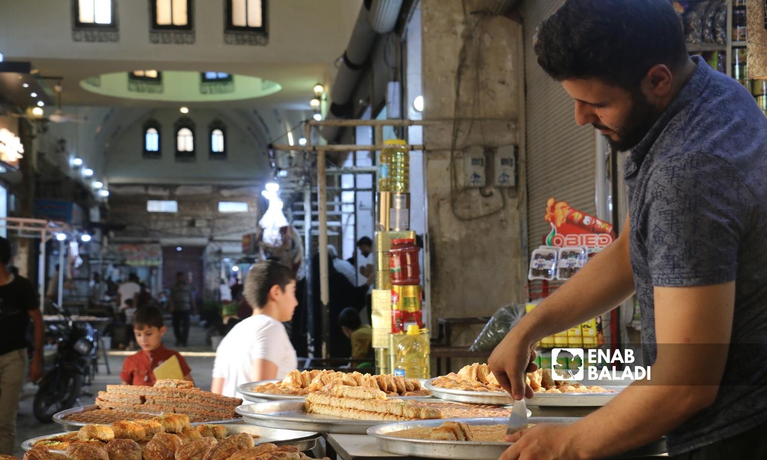 A man sells oriental sweets in the covered market of Azaz city in Aleppo’s northern countryside - 02 September 2022 (Enab Baladi/Dayan Junpaz)
