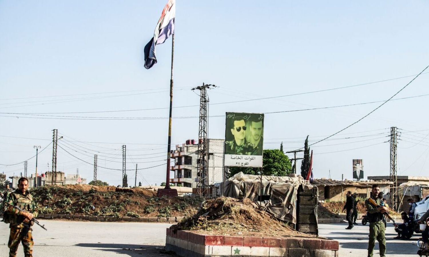 Members of the Asayish Internal Security Forces and the Syrian regime forces guard a checkpoint at the northern entrance to the Znoud neighborhood in Qamishli - 27 April 2021 (AFP)